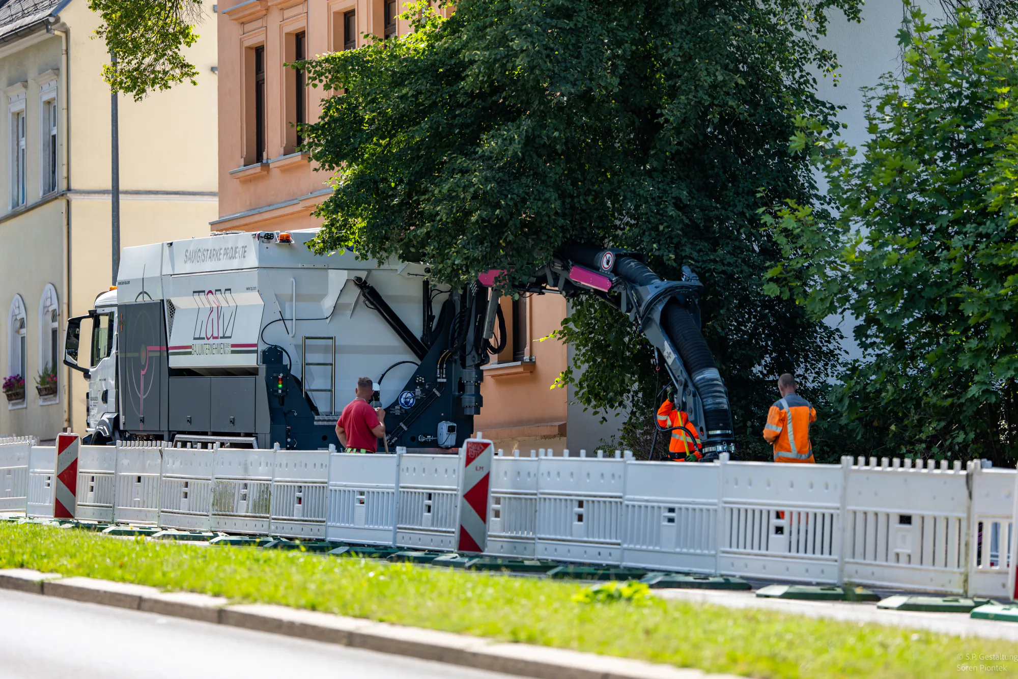 Firmeneigener Saugbagger mit Baustellenteam bei einem innerstädtischen Einsatz